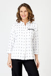 Cali Girls Betty Check Embroidered Blouse in White/Black.  Gingham check with contrast color embroidery.  Pointed collar button down blouse with hidden button placket.  3/4 sleeve with fold back cuff and button detail.  Coral zipper detail above left breast.  Back yoke with ring tab and inverted back pleat.  Relaxed fit._t_59841889599854