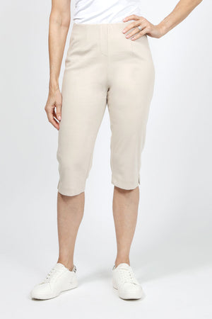 Holland Ave Julia Denim Pedal Pusher in Khaki. Pull on pant with elastic hidden waist and faux zipper pocket. Slim through leg. Side slits. 17" inseam._36030721032392