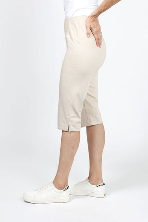 Holland Ave Julia Denim Pedal Pusher in Khaki. Pull on pant with elastic hidden waist and faux zipper pocket. Slim through leg. Side slits. 17" inseam._36030721097928