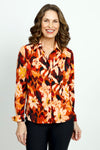 Cali Girls Floral Print Blouse in Red.  Abstract floral in shades of red orange and cream with touches of black.  Pointed collar button down.  Long sleeves with 1 button fold back cuff.  Back yoke.  Shirt tail hem.  Relaxed fit._t_52871633633646