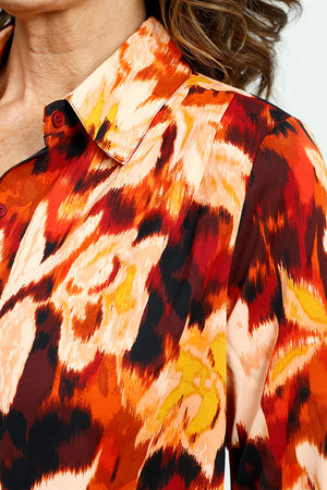 Cali Girls Floral Print Blouse in Red.  Abstract floral in shades of red orange and cream with touches of black.  Pointed collar button down.  Long sleeves with 1 button fold back cuff.  Back yoke.  Shirt tail hem.  Relaxed fit._52871633600878