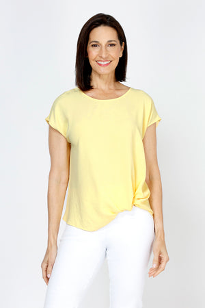 Top Ligne Airflow Twist Hem Top in Banana.  Lightly textured crew neck cap sleeve top with twist hem on left side. Keyhole opening at back neck with button closure.  Relaxed fit._59759859335534