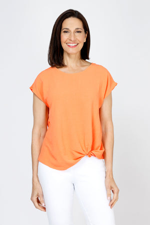 Top Ligne Airflow Twist Hem Top in Cantaloupe.  Lightly textured crew neck cap sleeve top with twist hem on left side. Keyhole opening at back neck with button closure.  Relaxed fit._59759859532142