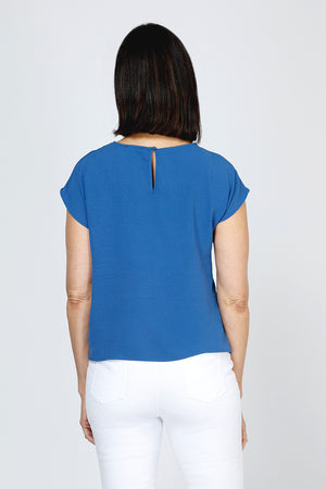 Top Ligne Airflow Twist Hem Top in Indigo.  Lightly textured crew neck cap sleeve top with twist hem on left side. Keyhole opening at back neck with button closure.  Relaxed fit._59759859401070