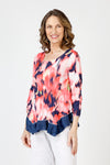 Top Ligne Blurred Flower Tee in Coral.  Coral and white blurred flowers on a navy background.  Scoop neck 3/4 sleeve tee with sewn edges.  Center raised seam.  Inseam solid navy asymmetrical flounce at hem.  Relaxed fit._t_59845645959534