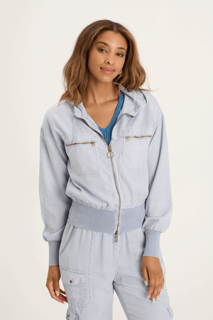 XCVI Karney Bomber in Spry Blue a light blue.  Zip front with attached hood and drawstring.  Long sleeves.  Ribbed banded hem and cuff.  Brushed twill body.  2 chest pockets with zipper closure.  Relaxed fit._59588992205166