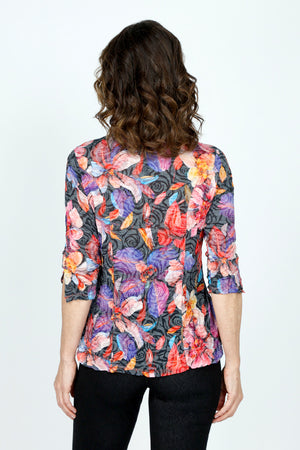 Top LIgne Mixed Flowers Snap Front Top in Multi.  Bright mixed large floral print on a black and gray rose print background.  Pointed collar snap front top with pairs of colored snaps.  3/4 sleeve with ruched hem and slit.  Shirt tail hem.  Relaxed fit._59570541068654