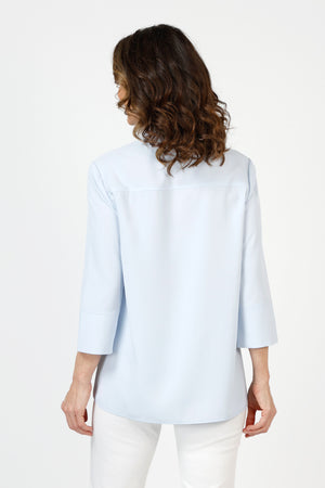 Beau Chemise Tulip Hem Blouse in Sky Blue. Pointed collar popover with 4 button placket. Tulip hem in front with 3 button trim on each side. 3/4 sleeve. Relaxed fit_59851083678062