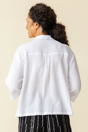 Habitat Crinkle Camp Shirt in White.  Pointed collar button down with black buttons.  Wrapped to front side seams with 3 button detail.  Single front patch pocket.  3/4 sleeve with 2 button detail placket cuff. Back yoke. Relaxed fit._59770350961006