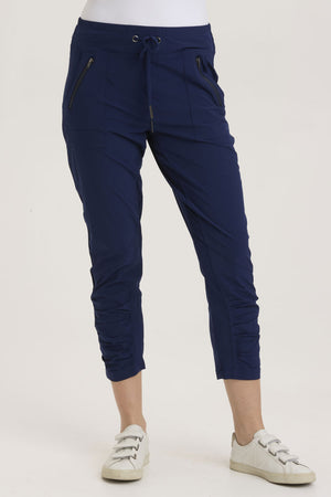 Wearables  Aksana Legging in Legion, a marine blue.  Elastic drawstring waist pant with ruching detail at the front from knee to hem.  Slim leg.  2 front pockets with diagonal zipper detail.  24 1/2" inseam._36290988048584