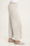 XCVI Pheodora Embroidered Pant in Whitecap, a light beige.  Terry elastic waistband.  2 deep front pockets with grommet detail and soft pleating.  Front center seams.  Hand-drawn embroidery.  2 back patch pockets. Wide leg. 29" inseam._t_59594501095790