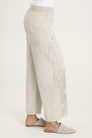 XCVI Pheodora Embroidered Pant in Whitecap, a light beige.  Terry elastic waistband.  2 deep front pockets with grommet detail and soft pleating.  Front center seams.  Hand-drawn embroidery.  2 back patch pockets. Wide leg. 29" inseam._59594501095790