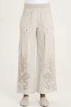 XCVI Pheodora Embroidered Pant in Whitecap, a light beige.  Terry elastic waistband.  2 deep front pockets with grommet detail and soft pleating.  Front center seams.  Hand-drawn embroidery.  2 back patch pockets. Wide leg. 29" inseam._t_59594501063022