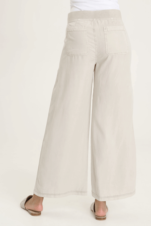 XCVI Pheodora Embroidered Pant in Whitecap, a light beige.  Terry elastic waistband.  2 deep front pockets with grommet detail and soft pleating.  Front center seams.  Hand-drawn embroidery.  2 back patch pockets. Wide leg. 29" inseam._59594501128558