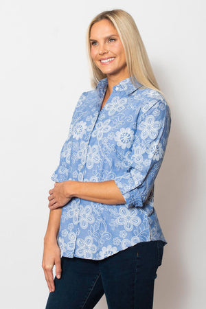 Sno Skins Embroidered Woven Blouse in Wedgewood blue.  Pointed collar button down with white floral  embroidery.  Long sleeves with button cuff and roll button tab.  Shirttail hem.  Relaxed fit._59765753839982