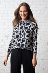 Olivia by Habitat Pleats Circles Jackets in Black.  Abstract circle print.   Horizontal mini accordion pleat button down with pointed collar.  Bracelet length sleeves.  Straight hem. Relaxed fit._t_59821191954798