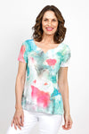 Top Ligne Lace Trim Tie Dye Top in Multi.  Bright teal and pink tie dye/watercolor top on a white background.  Sublimation printed allowing white streaks to peak through.  Notched v neck short sleeve a line top.  Asymmetric lace inset at hem.  Relaxed fit._t_35487920390344