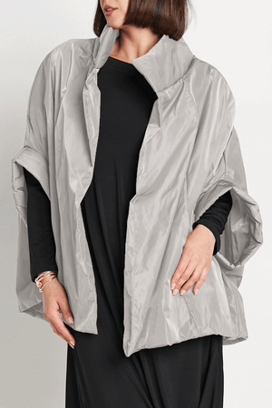 Planet Nylon Chic Cape in Titanium. Cocoon shaped double faced nylon jacket with 2 openings for arms. Cross between cape and a poncho._59597913686382