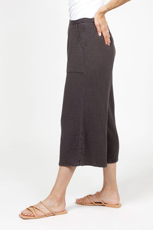 Organic Rags Gauze Pocket Crop in Graphite. Pull on cotton gauze pant with 3/4" contoured flat front waistband, elastic back. Falls straight through the hip, thigh and leg. 2 front pockets. 22" inseam._35151267889352