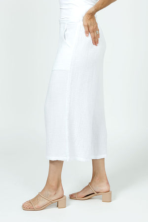 Organic Rags Gauze Pocket Crop in White. Pull on cotton gauze pant with 3/4" contoured flat front waistband, elastic back. Falls straight through the hip, thigh and leg. 2 front pockets. 22" inseam._35729899913416