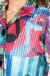 Frederique Abstract Floral Mesh Jacket in Multi.  Bright floral print.  Alternating strips of solid fabric and mesh with a perforated look. Wired convertible collar, button down with 3 oversized black buttons.  3/4 sleeve with tulip pleated cuff. A line shape.  Relaxed fit._t_59651577938286