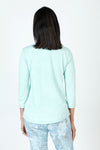 Organic Rags Ruffle Henley in Tiffany, an aqua shade.  Crew neck with split placket. Ruffle trim on 1 side of placket.  3/4 sleeve.  Curved hem.  Relaxed fit._t_59648073138542