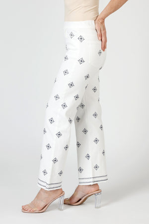 Organic Rags Geometric Embroidered Ankle Jean in White. Blue embroidery in diamond pattern. Pull on denim with elastic waist.  5 pocket styling.  Embroidered double border.  Slightly flared leg.  28" inseam. _59845497684334