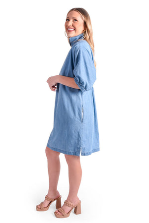 Emily McCarthy Denim Chambray Poppy Dress in Light Denim. Convertible collar split neck dress. Dolman elbow length sleeve with elastic cuff. Side seam pockets. Side slits. Relaxed fit._35611072659656
