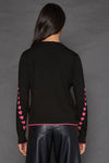 Lisa Todd Love Notes Sweater in Black.  Crew neck long sleeve cotton/cashmere knit.  Pink intarsia knit hearts wrap around sleeves.  Rib trim at neck, hem and cuff.  Pink tipping at hem and cuff.  Relaxed fit._t_52882964152686