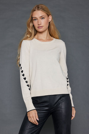 Lisa Todd Love Notes Sweater in Sheepskin.  Crew neck long sleeve cotton/cashmere knit.  Black intarsia knit hearts wrap around sleeves.  Rib trim at neck, hem and cuff.  Black tipping at hem and cuff.  Relaxed fit._52882964185454