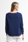 Zaket & Plover Round Bottom V Neck Sweater in Navy.  V neck raglan long sleeve sweater.  Rainbow stripe inset at neckline.  Curved hem with narrow stripe trim.  Contrast color hand stitching on right armhole.  Rib trim at neck and cuff. Rainbow stripe tipping on sleeves. Relaxed fit._t_59493869420910